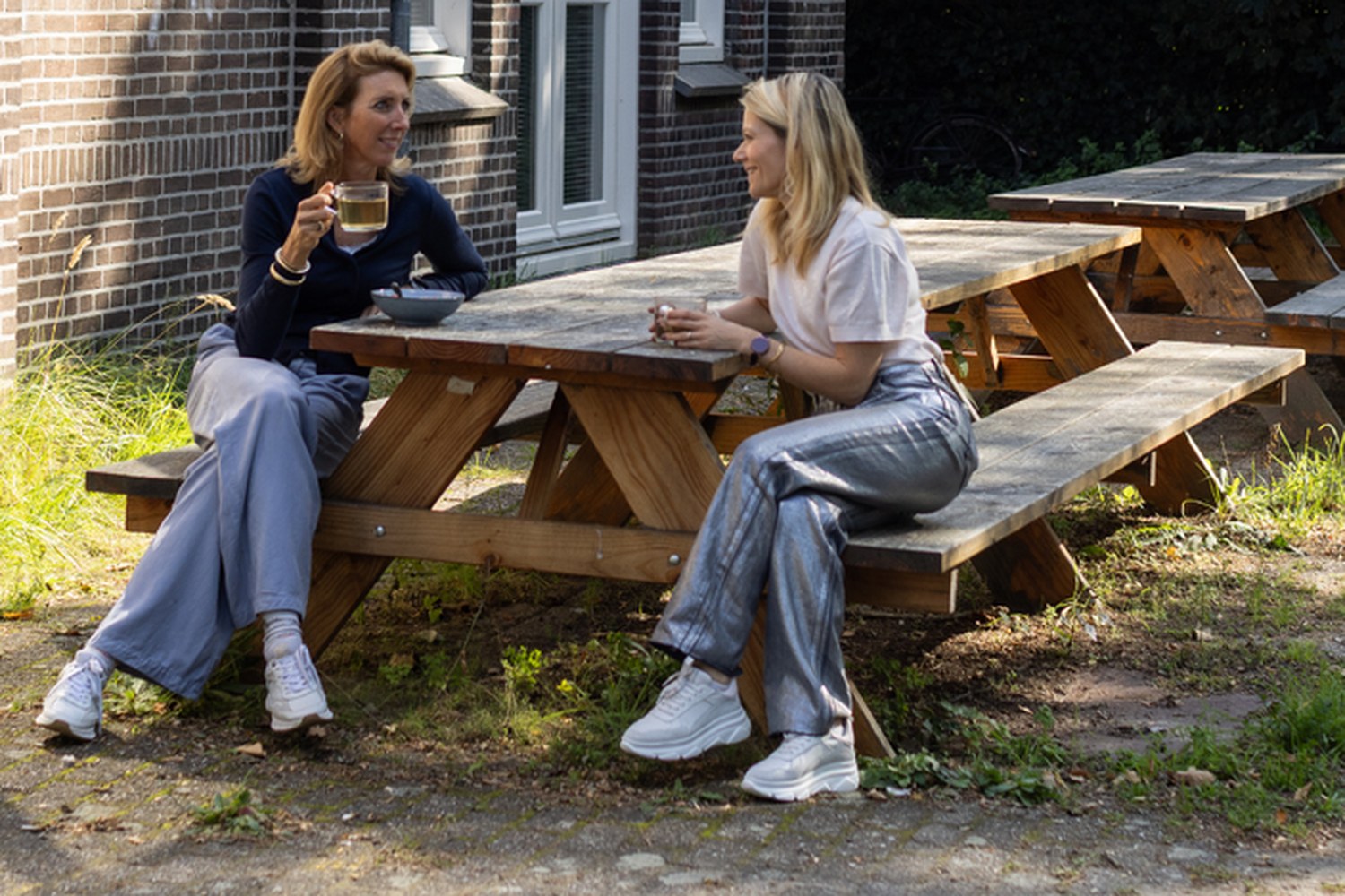 Twee collega's in gesprek aan een picknicktafel buiten